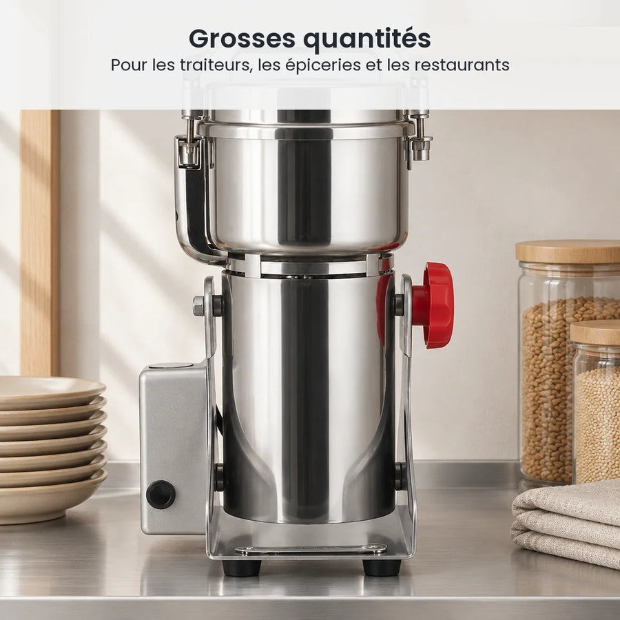Grand moulin électrique oscillant inox 2 500 g rangé sur une étagère inox, à côté d'assiettes et de bocaux de grains