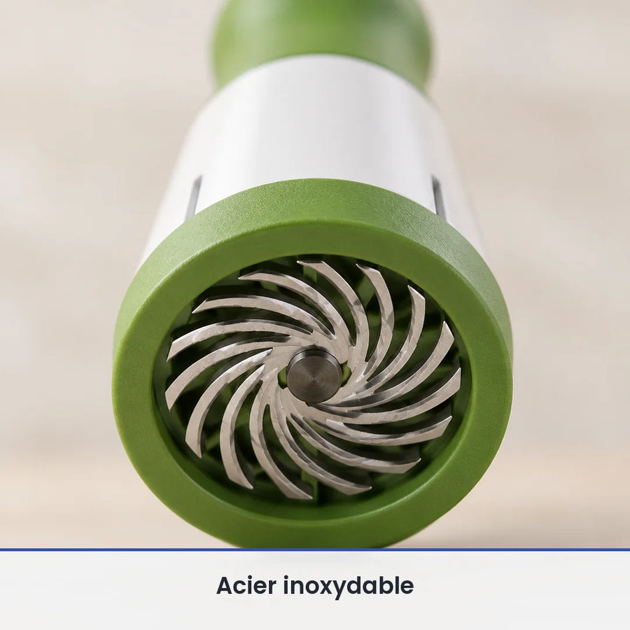 Gros plan sur la grille de coupe ronde verte et ses lames inox en spirale, à la base du moulin à herbes manuel