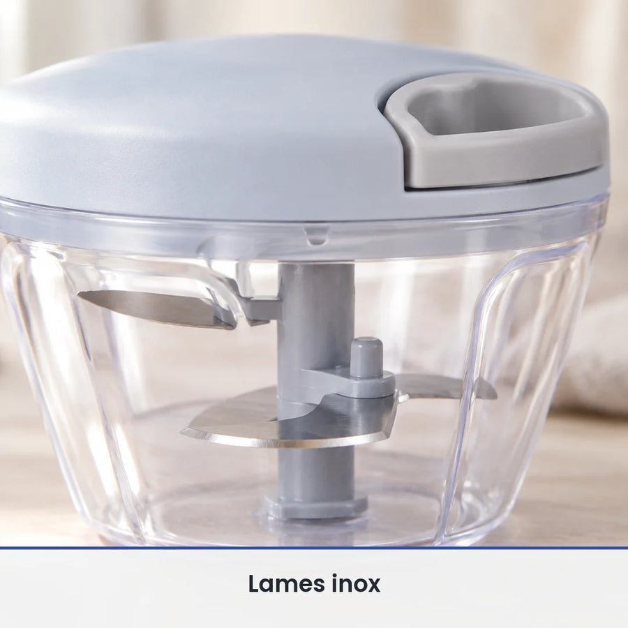 Gros plan sur les lames inox fixées sur l'axe gris du hachoir manuel à ficelle, vues à travers le bol transparent fermé