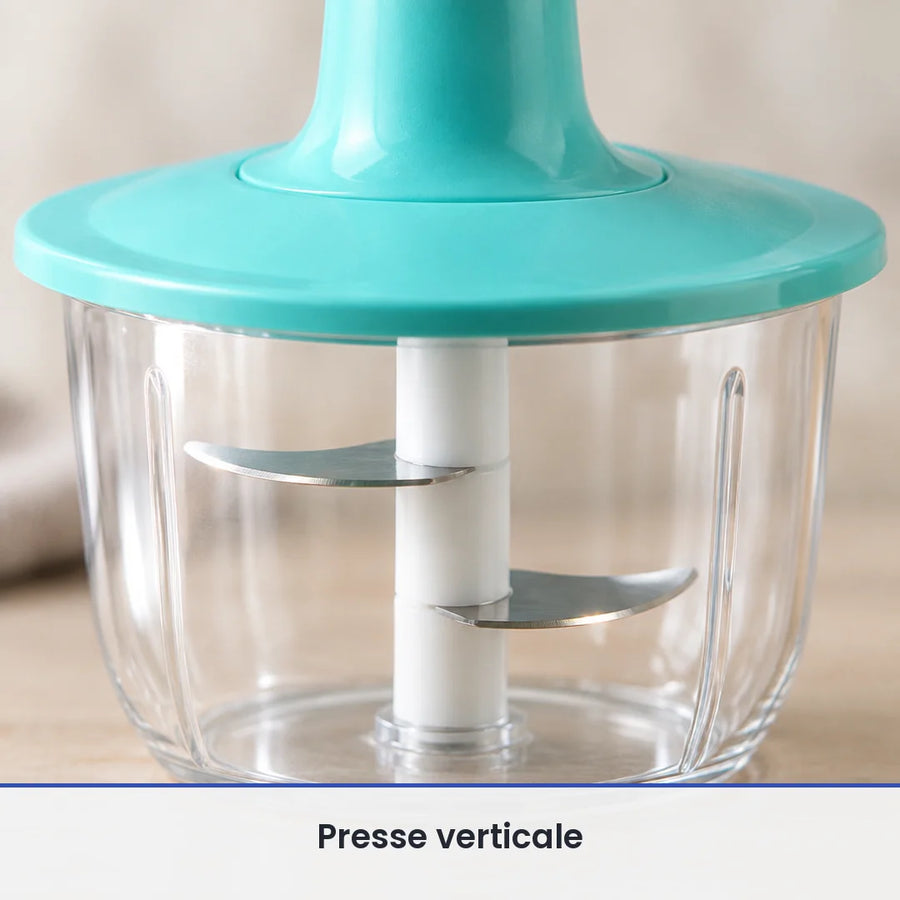 Gros plan sur les lames inox fixées sous la collerette turquoise du hachoir à presse, vues à travers le bol transparent