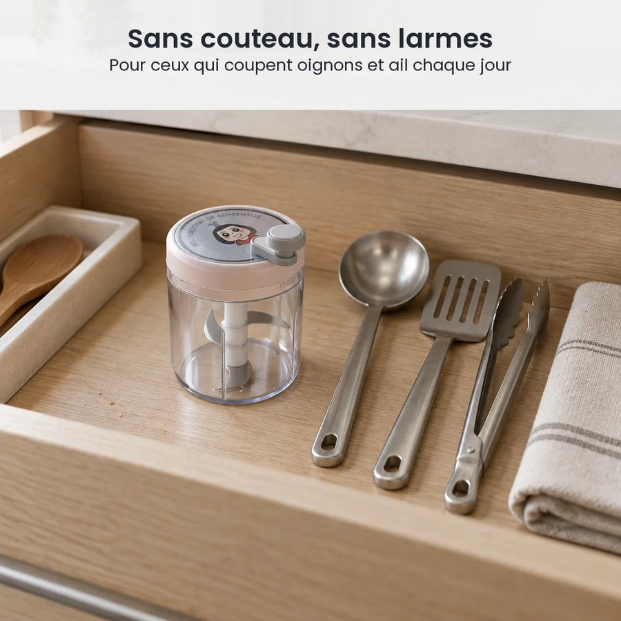 Hachoir manuel rotatif 400 ml à couvercle rose pâle rangé dans un tiroir de cuisine en bois clair