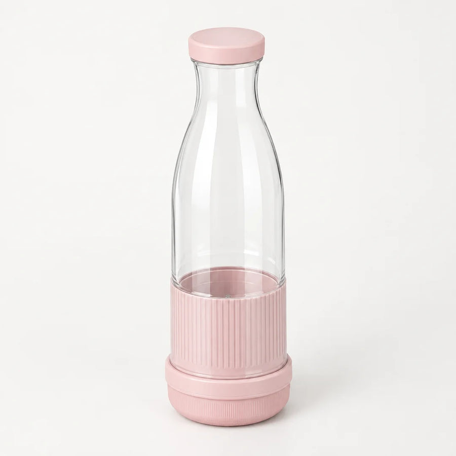 Blender bouteille portable rose poudré avec bouteille transparente au col étroit et base striée rose, sur fond blanc cassé