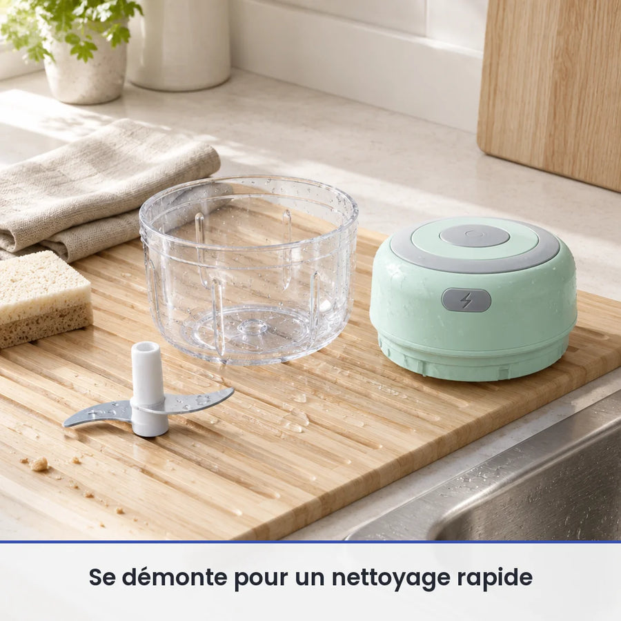 Bol transparent et couteau du mini hachoir électrique vert menthe lavés sur une planche près de l'évier, moteur au sec
