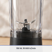 Gros plan sur les lames inox du blender portable noir 600 ml, vues à travers la paroi du gobelet transparent fermé