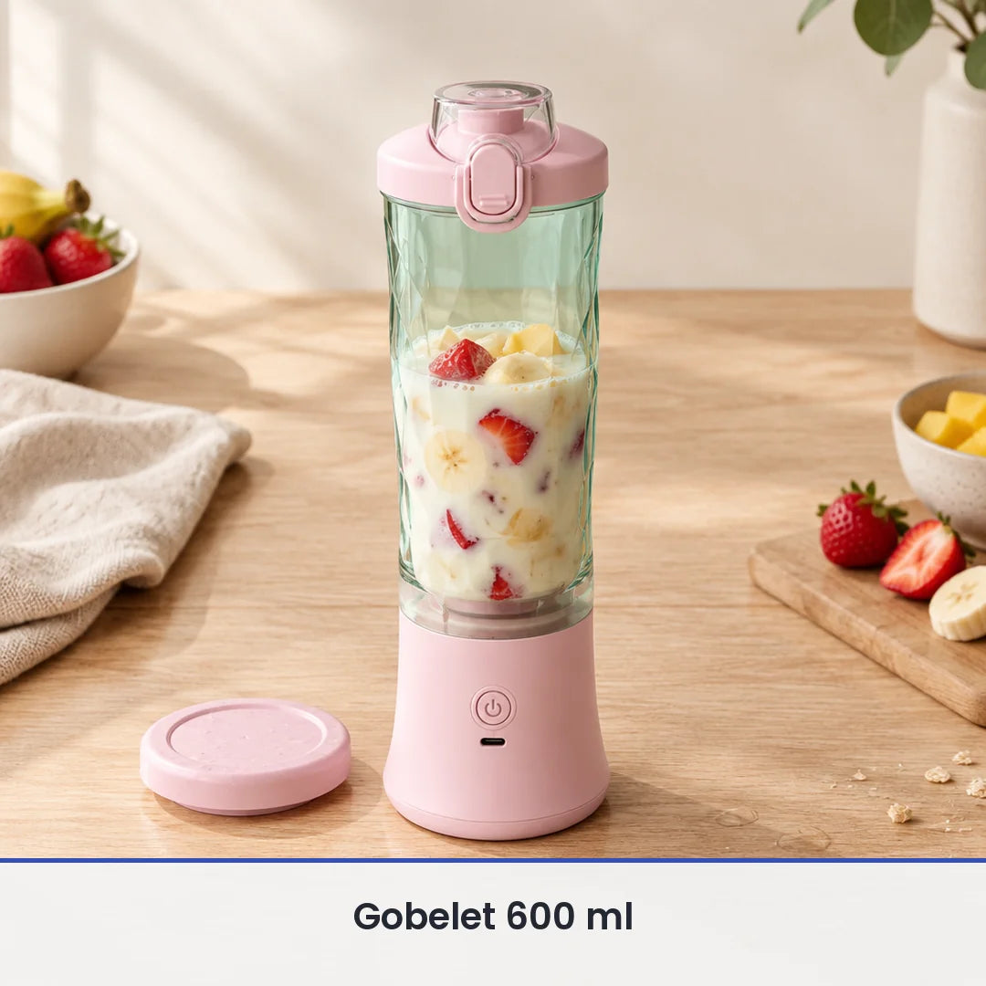 Gobelet vert d'eau du blender portable rose rempli aux deux tiers de fraises, banane et lait, sur une table en bois