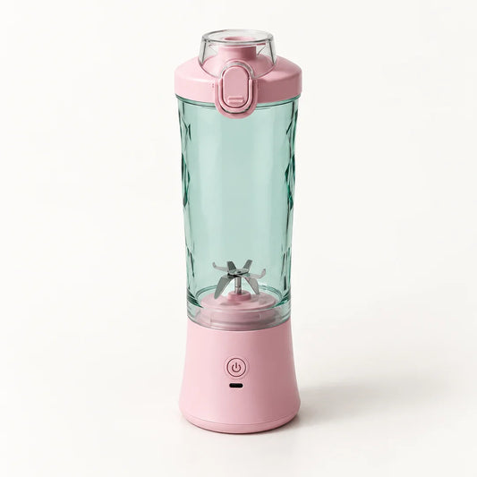 Blender portable 600 ml rose avec gobelet vert d'eau à facettes et couvercle rose à clapet, sur fond blanc cassé