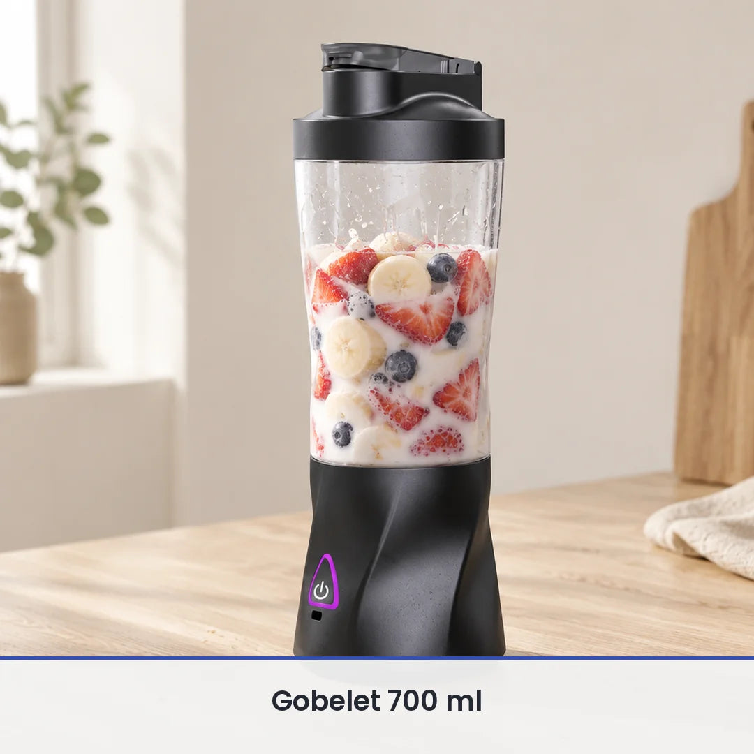 Grand gobelet du blender portable 700 ml rempli aux deux tiers de fraises, banane, myrtilles et lait, sur bois clair
