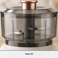 Gros plan sur les lames inox du hachoir électrique 350 ml beige crème, vues à travers le bol gris fumé fermé