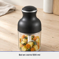 Bol en verre de 600 ml du hachoir électrique 350 W rempli aux deux tiers de légumes cuits, sur un plan en bois clair