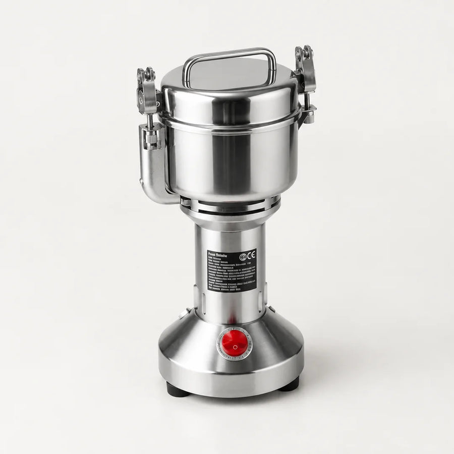 Moulin électrique vertical en inox brossé 150 g, cuve à couvercle et attaches latérales, bouton rouge, sur fond blanc cassé