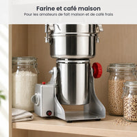 Moulin électrique inox 800 g rangé dans un placard de cuisine clair, entre un bocal de farine et des bocaux de grains