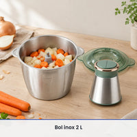 Bol inox de 2 L du hachoir électrique vert sauge rempli d'oignons et de carottes, couvercle et moteur posés à côté
