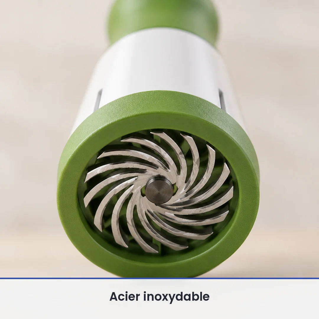Gros plan sur la grille de coupe ronde verte et ses lames inox en spirale, à la base du moulin à herbes manuel