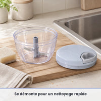 Bol transparent et axe à lames du hachoir manuel à ficelle lavés sur un égouttoir, couvercle bleu-gris posé au sec