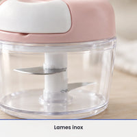 Gros plan sur les lames inox fixées sur l'axe blanc du hachoir à ficelle rose, vues à travers le bol transparent