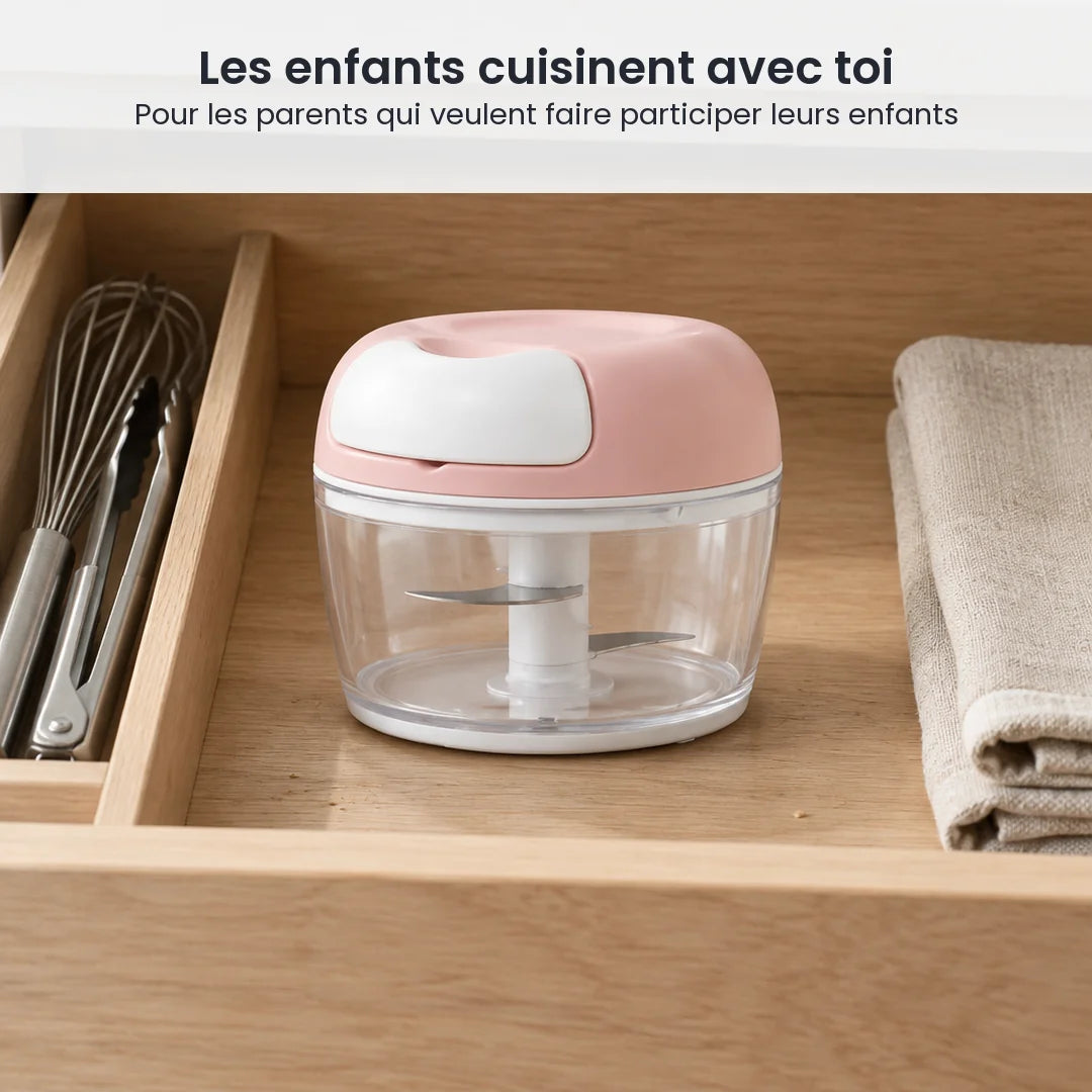 Hachoir manuel à ficelle rose poudré rangé dans un tiroir de cuisine familiale, à côté d'un fouet et d'un torchon