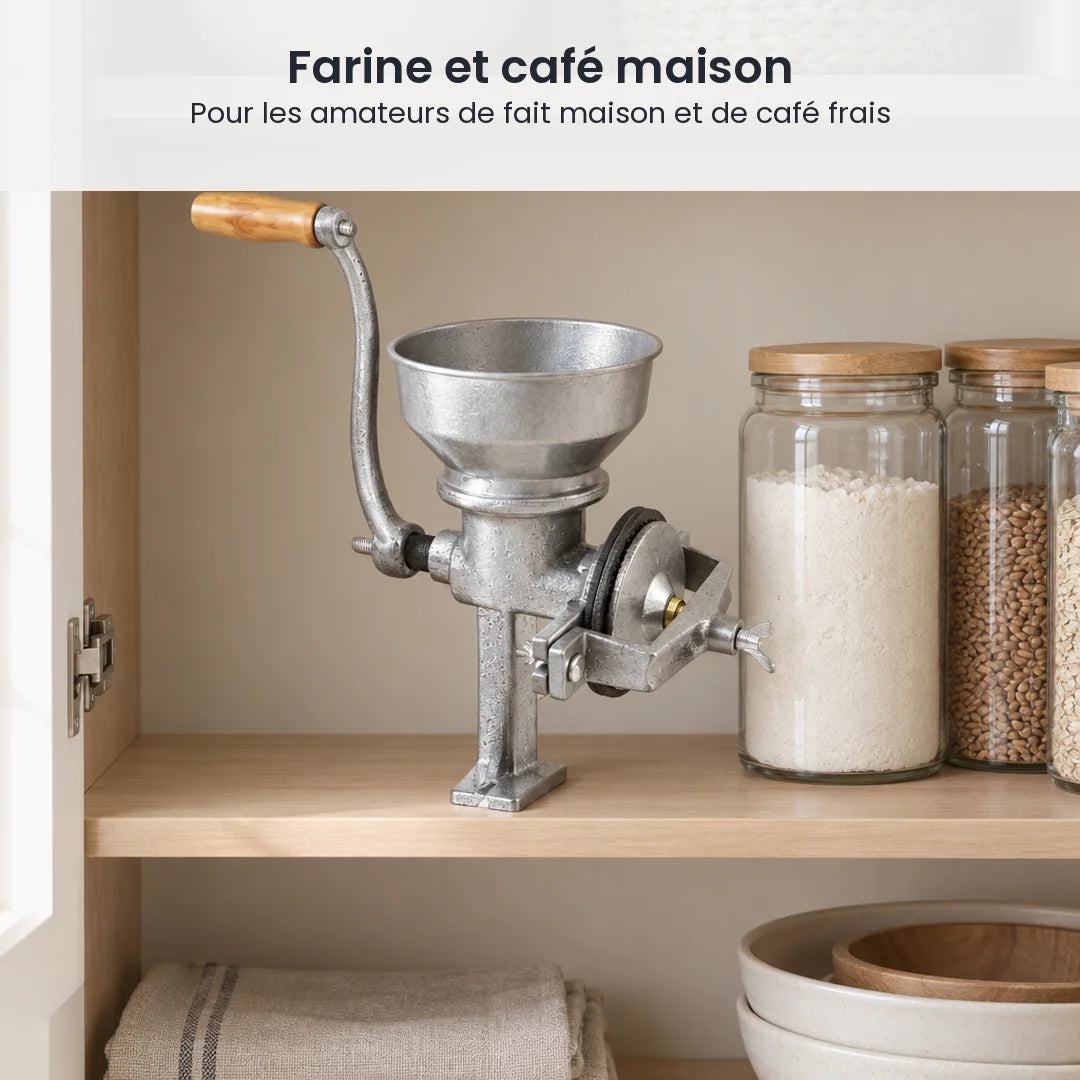 Moulin manuel en fonte argenté rangé sur l'étagère d'un placard de cuisine, à côté de bocaux de farine et de grains