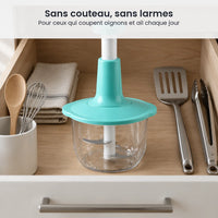 Hachoir à presse verticale turquoise rangé dans un tiroir de cuisine, entre spatule, fouet et cuillère en bois
