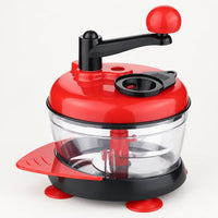 Hachoir manuel à manivelle rouge à bras noir et boule rouge, bol transparent, ventouses et raclette rouges, fond blanc cassé
