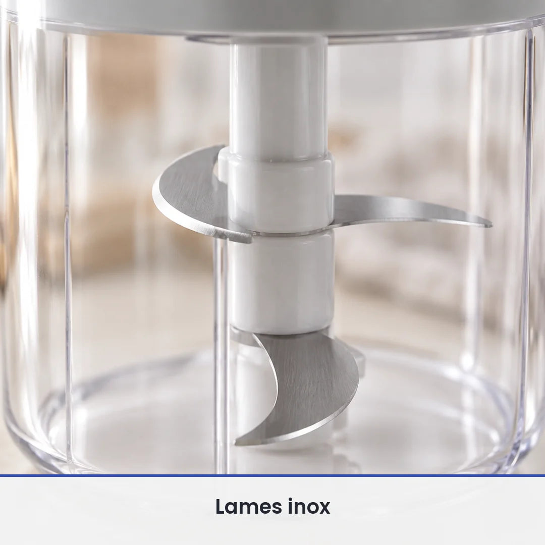 Gros plan sur les lames inox du hachoir manuel rotatif 400 ml, vues à travers le bol transparent