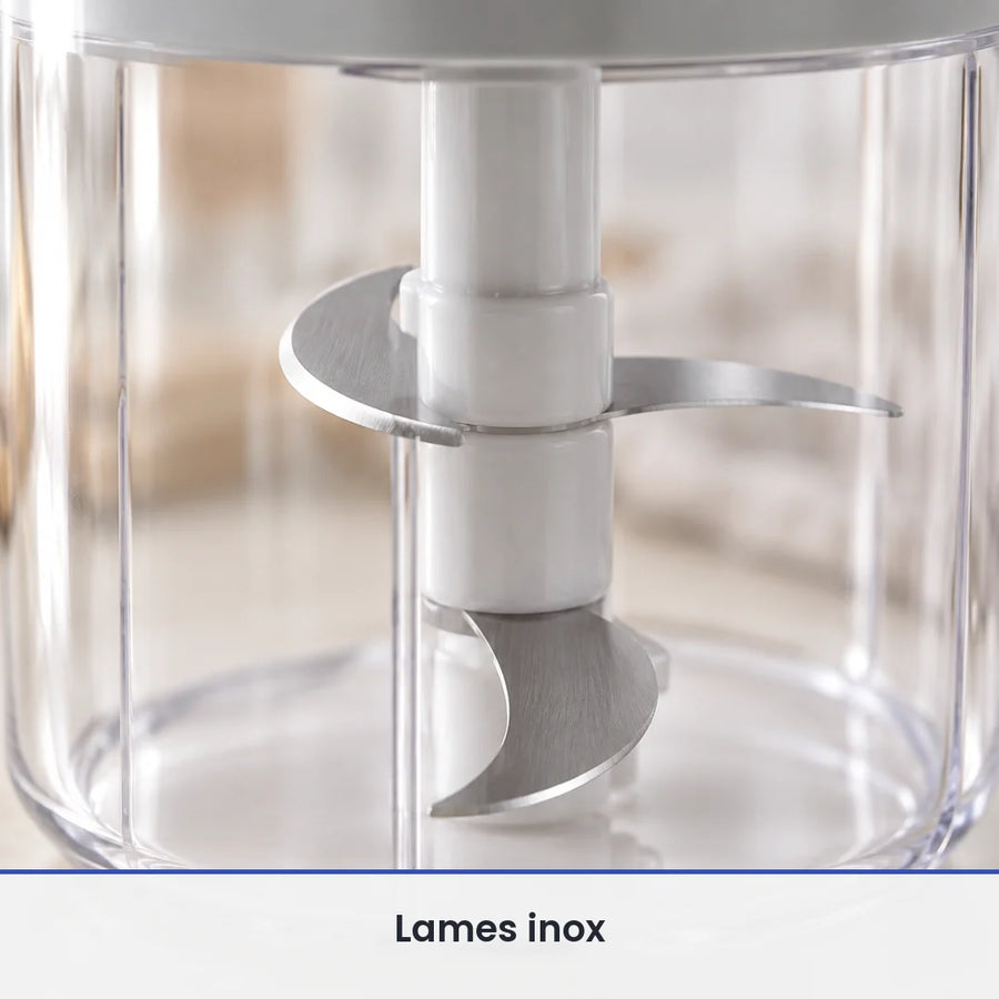 Gros plan sur les lames inox du hachoir manuel rotatif 400 ml, vues à travers le bol transparent