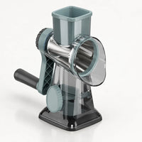 Râpe rotative à manivelle gris bleuté translucide, trémie carrée, tambour inox, base gris foncé à ventouse, sur fond clair