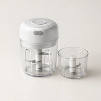 Mini hachoir électrique blanc 30 W monté sur son bol de 250 ml, second bol transparent de 100 ml à côté, sur fond blanc cassé