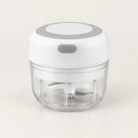Mini hachoir électrique blanc 30 W avec bol transparent de 100 ml et bouton gris à éclair, vu en plongée sur fond blanc cassé