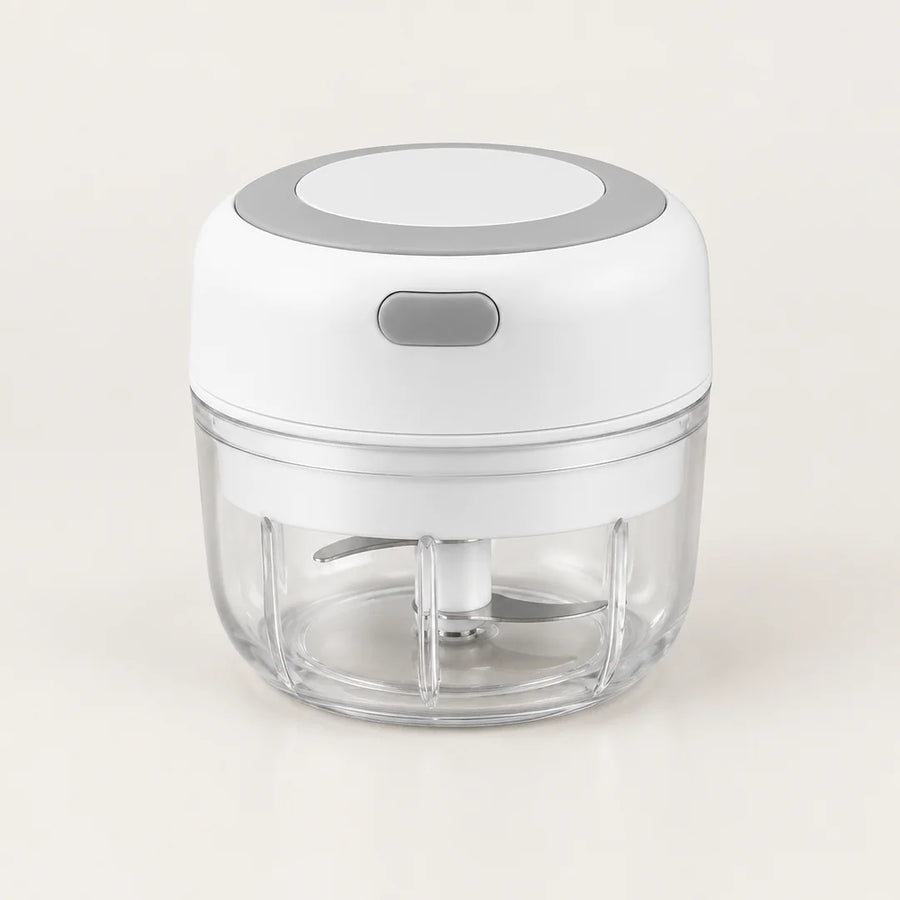Mini hachoir électrique blanc 30 W avec bol transparent de 100 ml et bouton gris à éclair, vu en plongée sur fond blanc cassé