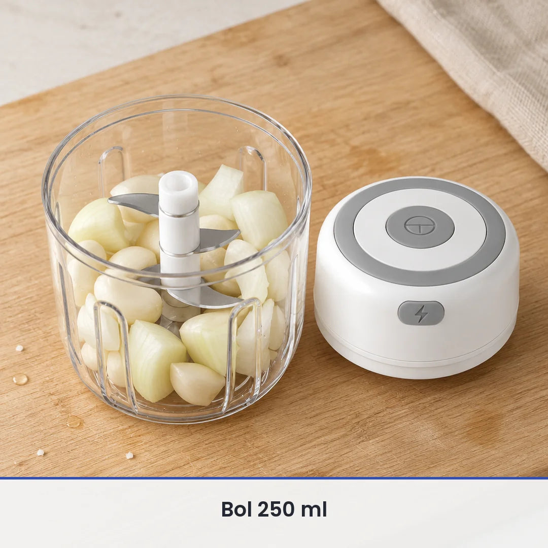 Bol transparent de 250 ml du mini hachoir électrique blanc rempli de gousses d'ail, couvercle-moteur posé sur la planche