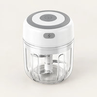 Mini hachoir électrique blanc 30 W avec bol transparent de 250 ml et bouton gris à éclair, vu en plongée sur fond blanc cassé