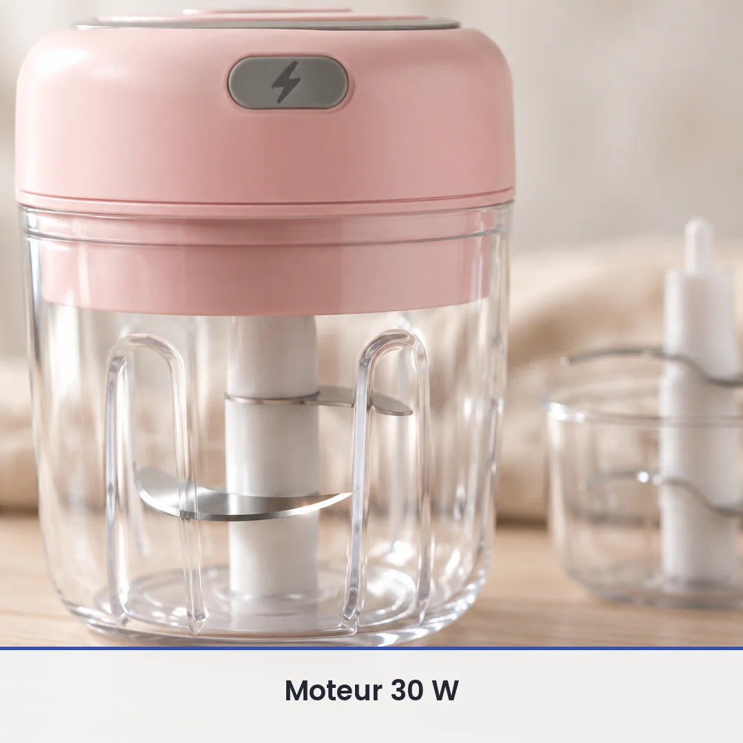 Gros plan sur le couteau inox du mini hachoir électrique rose, vu à travers la paroi du bol transparent de 250 ml fermé