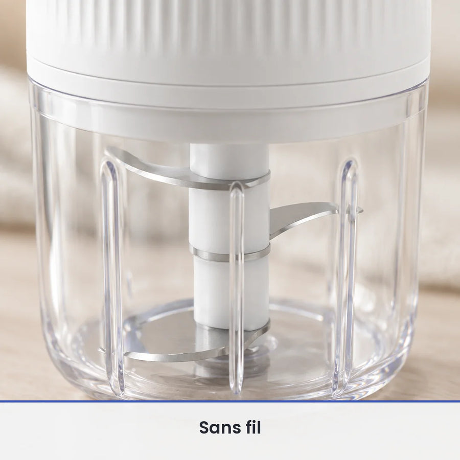Gros plan sur le couteau inox du mini hachoir sans fil blanc, vu à travers la paroi du bol transparent de 250 ml fermé