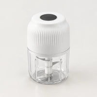 Mini hachoir électrique sans fil blanc à couvercle cannelé et cadran noir sur le dessus, bol transparent de 250 ml