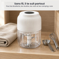 Mini hachoir électrique sans fil blanc rangé dans un bac de rangement en bois de kitchenette, à côté d'un torchon