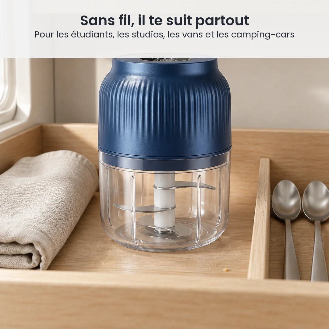 Mini hachoir électrique sans fil bleu marine rangé dans un tiroir de kitchenette en bois clair, à côté d'un torchon