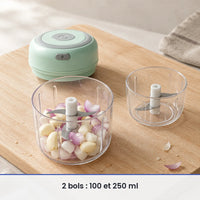 Bol de 250 ml du mini hachoir vert menthe rempli d'ail et d'échalote, couvercle-moteur et bol de 100 ml posés à côté
