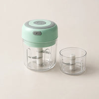 Mini hachoir électrique vert menthe 30 W monté sur son bol de 250 ml, second bol de 100 ml à côté, sur fond blanc cassé