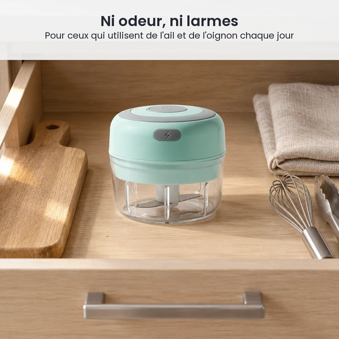 Mini hachoir électrique vert menthe 100 ml rangé dans un tiroir de cuisine en bois clair, à côté d'une planche et d'un fouet