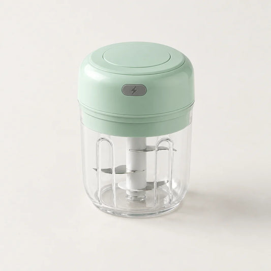 Mini hachoir électrique vert menthe 30 W avec bol transparent de 250 ml et bouton gris à éclair, sur fond blanc cassé